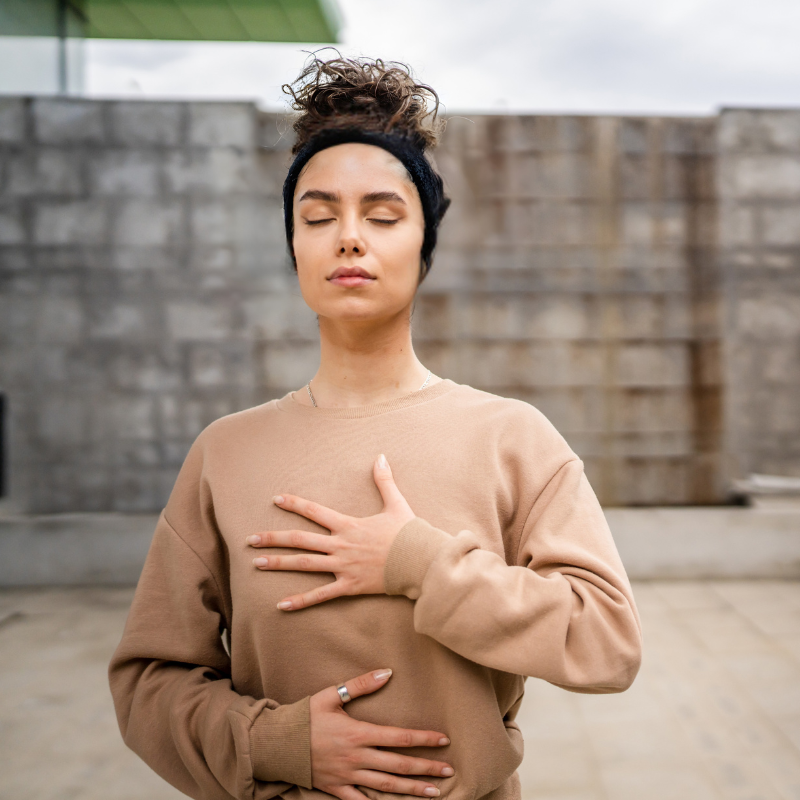 woman holding heart and solar plexus chakra