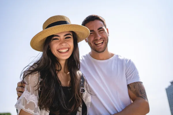 Therapy for couples: a laughing couple, a woman in a straw hat and a man with his arm around her
